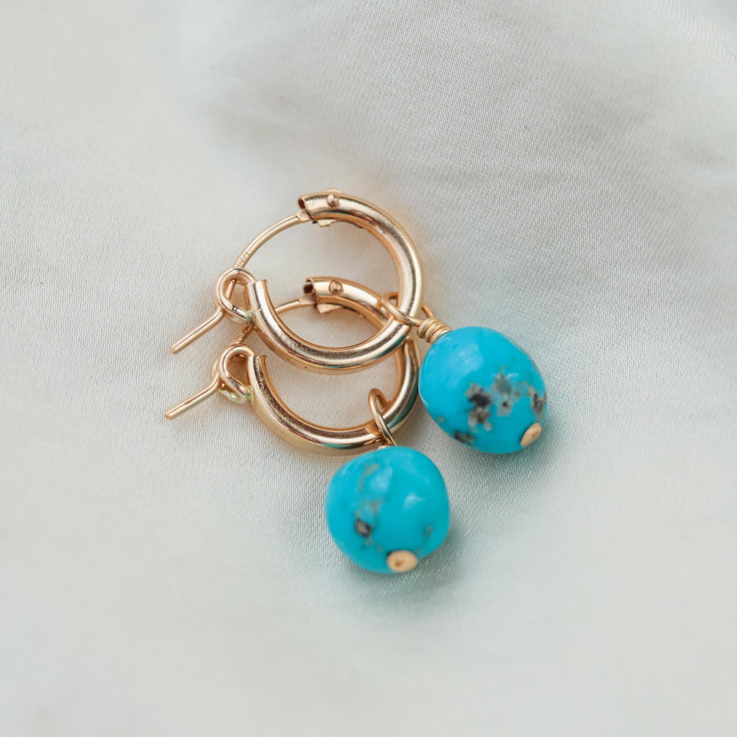Earthly Abundance Sleeping Beauty Turquoise hoop earrings featuring vibrant turquoise stones and sterling silver hoops.