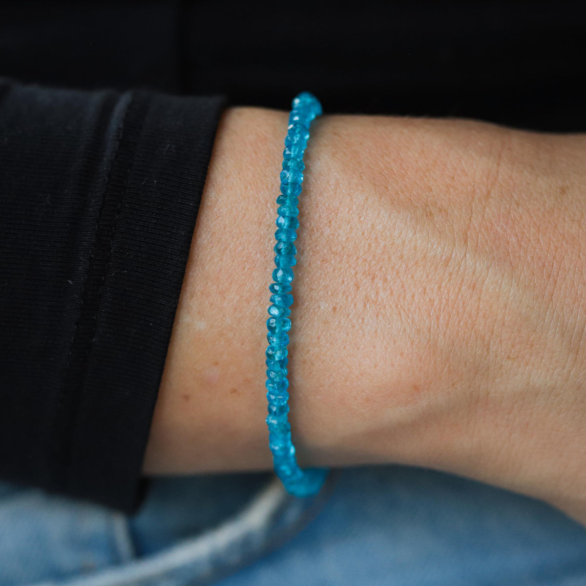 A 14K gold apatite bracelet with polished blue-green gemstone beads, displayed on a neutral background.