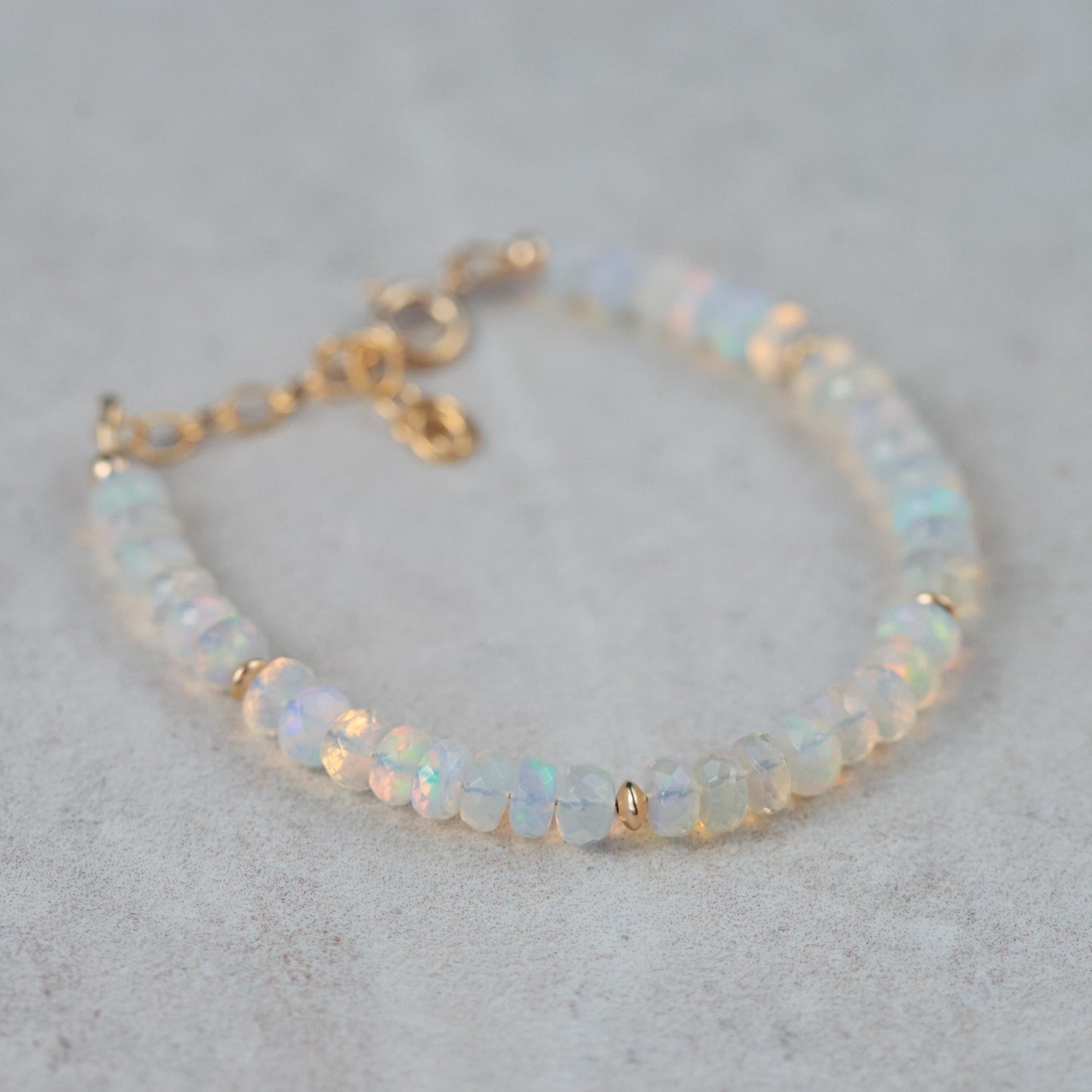 Ethiopian Welo Opal dainty bracelet with 14K gold setting, featuring vibrant opal stones on a delicate chain.