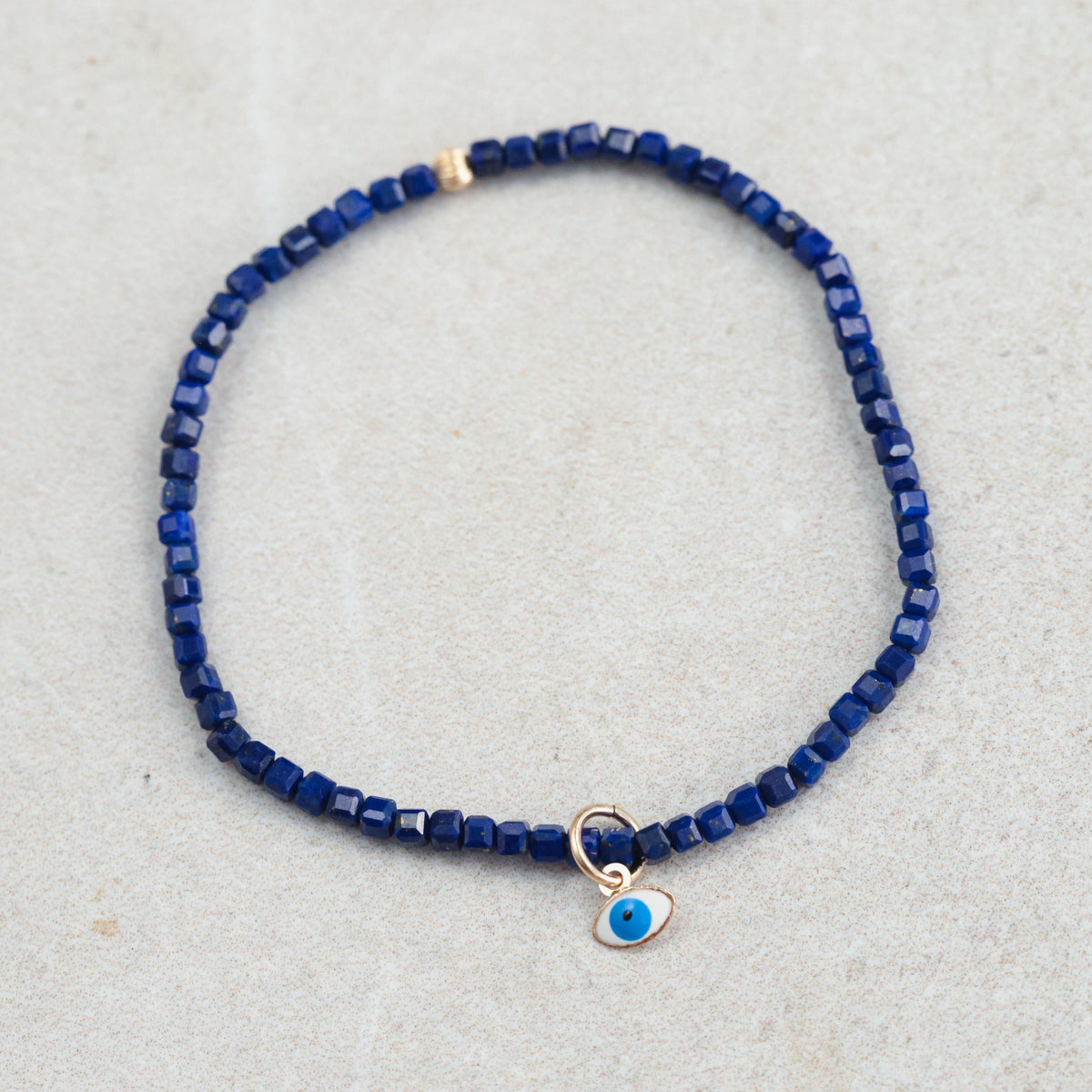 Lapis Lazuli Evil Eye pendant in 14K gold from Earthly Abundance, featuring a vibrant blue gemstone with gold accents.