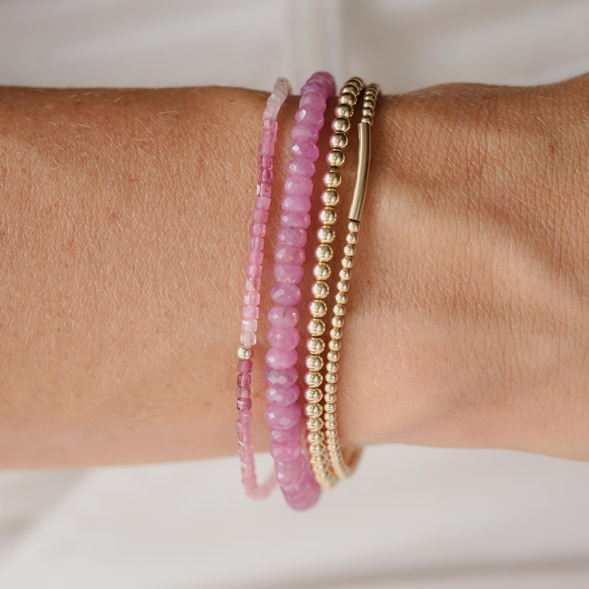 Pink tourmaline cube bracelet with 14K gold accents, featuring polished pink gemstones on a delicate chain.