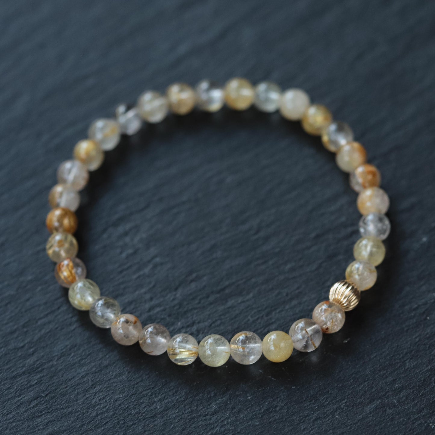 Golden rutilated quartz gemstone pendant in 14K gold setting, showcasing golden rutile inclusions and polished surface.