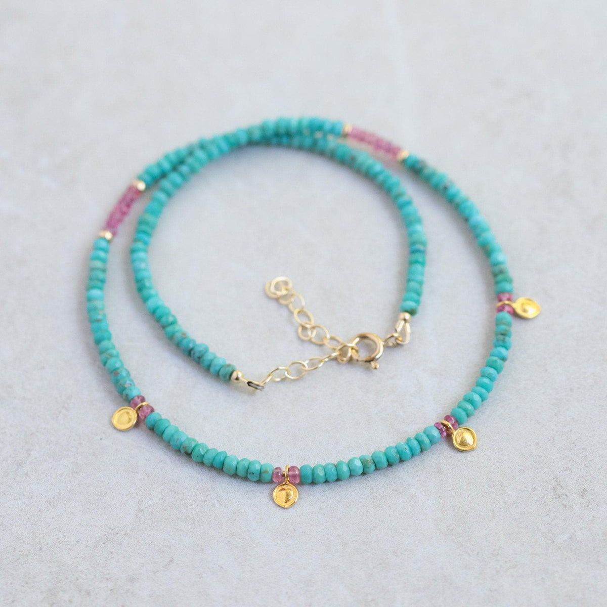 Turquoise and pink sapphire necklace featuring vibrant gemstones set in a delicate sterling silver chain.