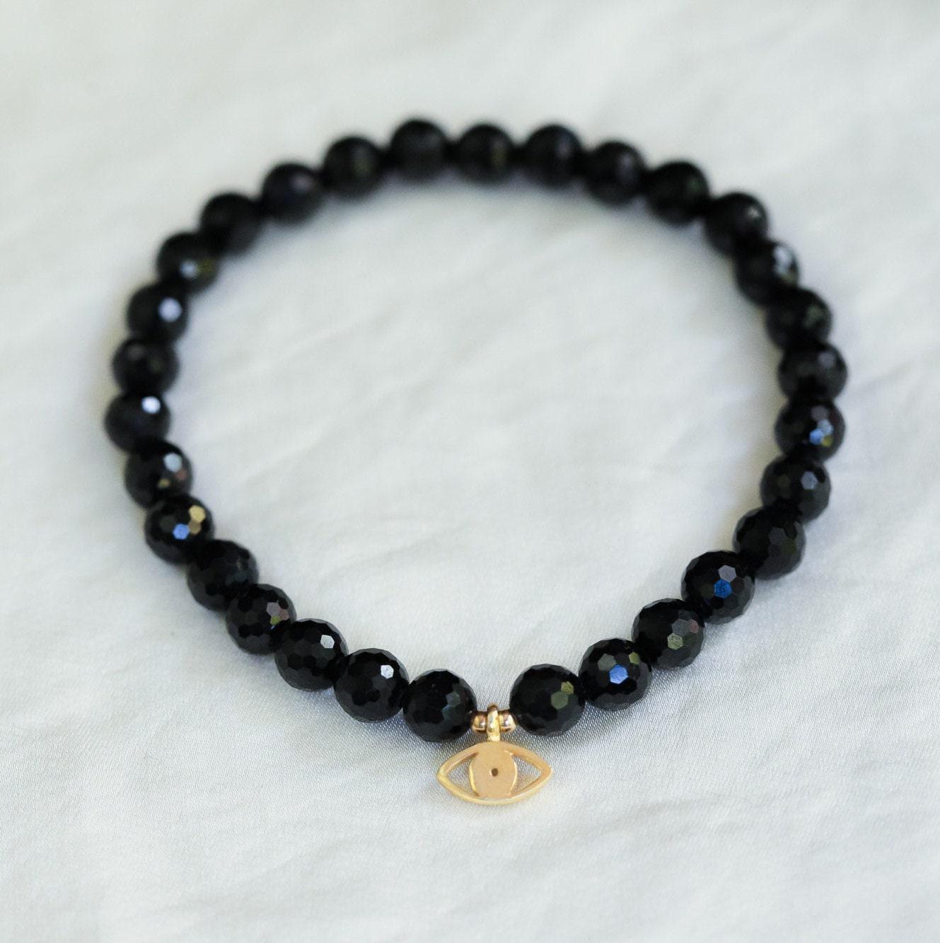 Black Tourmaline Evil Eye pendant from Earthly Abundance featuring protective evil eye charm and polished black gemstone.
