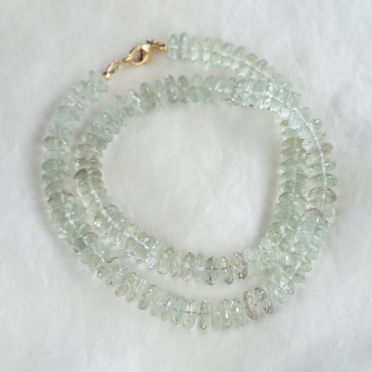 Green amethyst necklace with 14K gold chain from Earthly Abundance, featuring a vibrant green gemstone pendant.