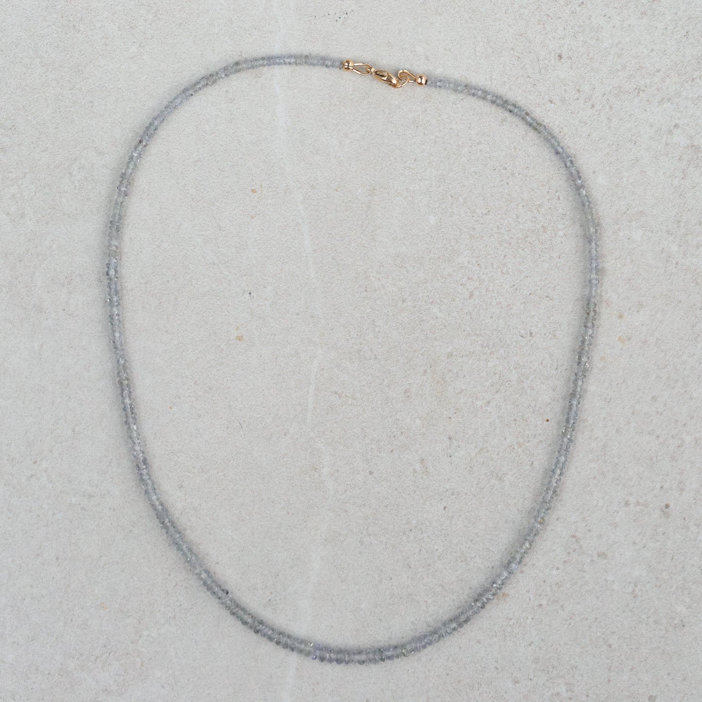 Grey sapphire necklace in 14K gold featuring a delicate pendant, displayed on a neutral background.