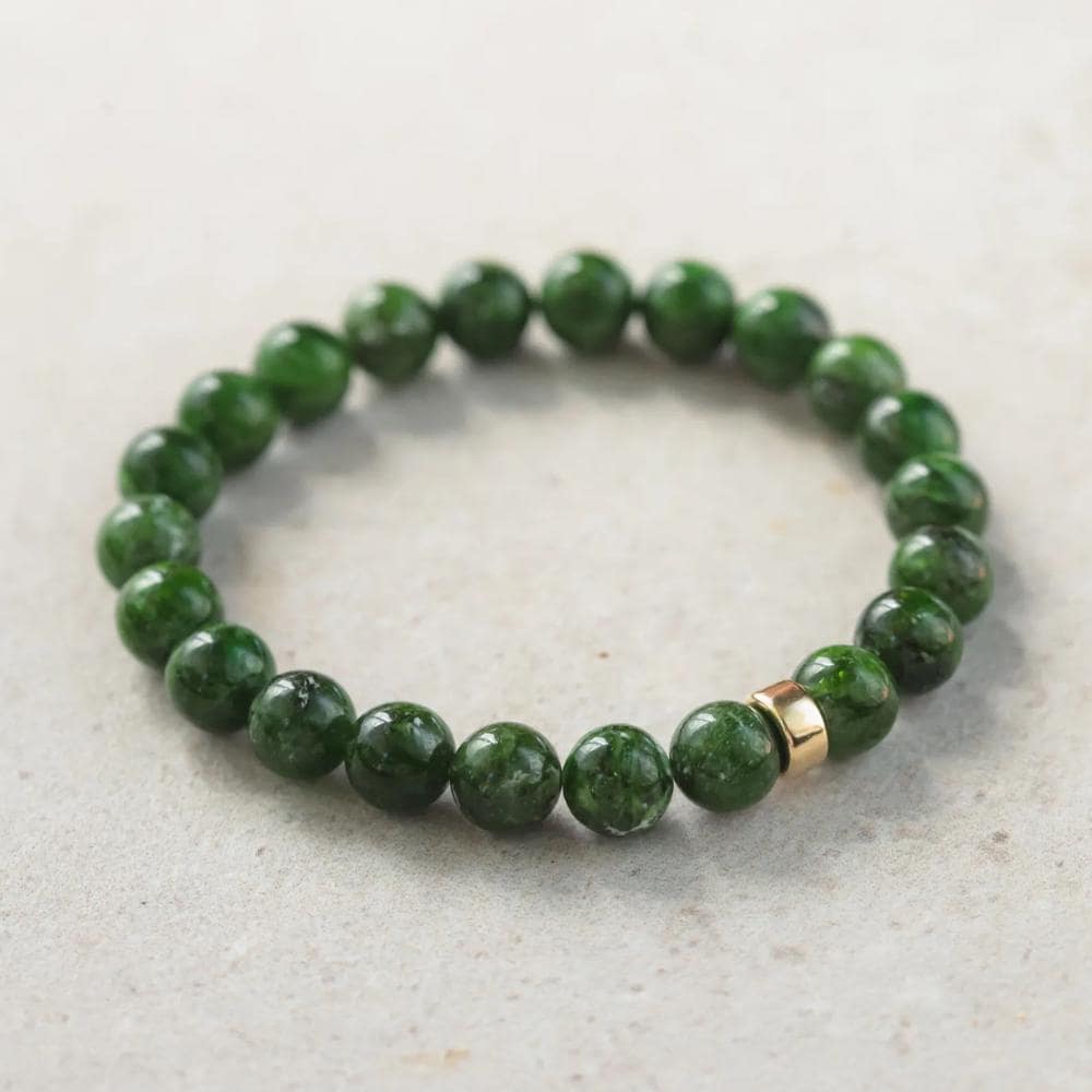 Chrome dioptase gemstone in 14K setting, showcasing vibrant green mineral with intricate natural patterns.