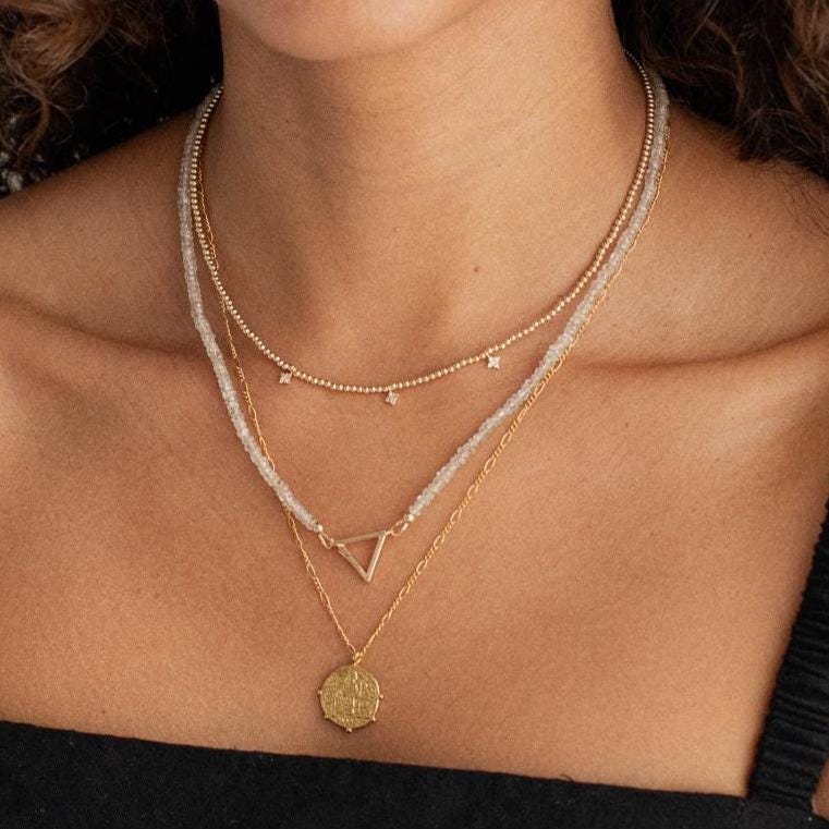 14K zircon triangle necklace by Earthly Abundance featuring a sparkling geometric pendant on a delicate chain.