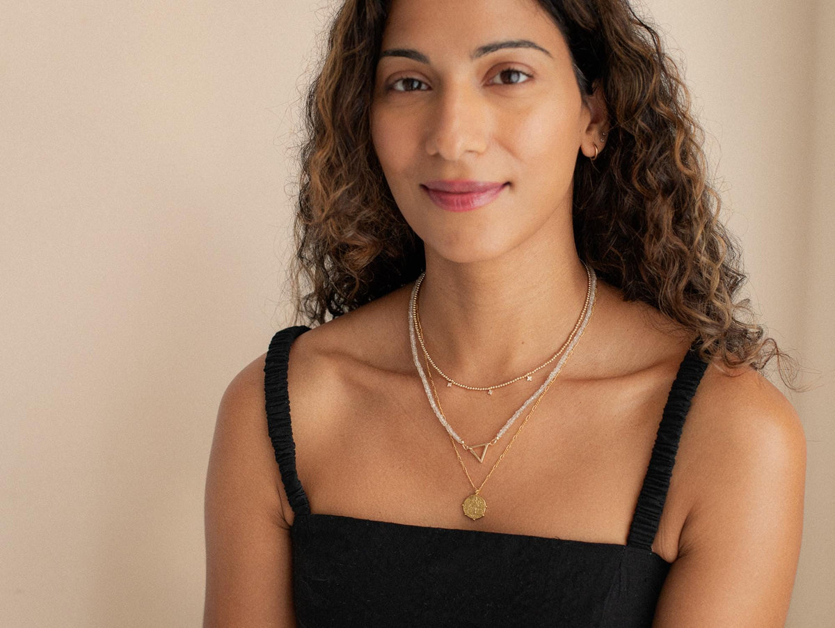 14K zircon triangle necklace by Earthly Abundance featuring a sparkling geometric pendant on a delicate chain.