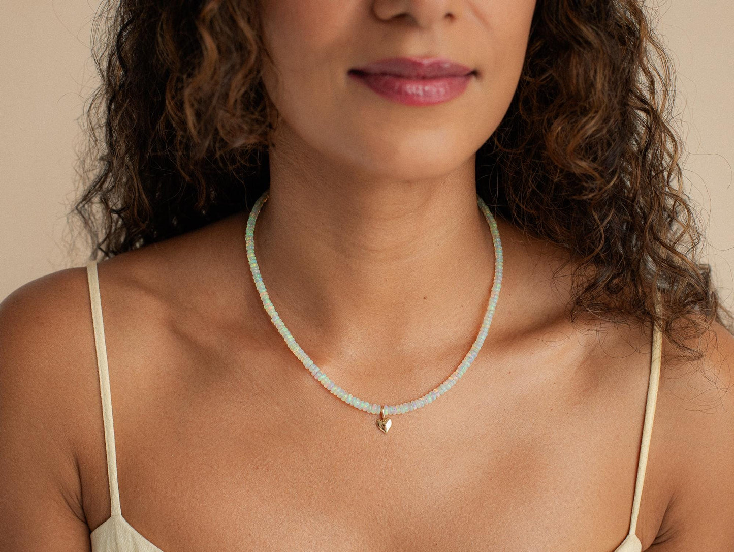 Ethiopian Opal Heart Necklace with 14K gold chain from Earthly Abundance, showcasing a shimmering heart-shaped opal pendant.