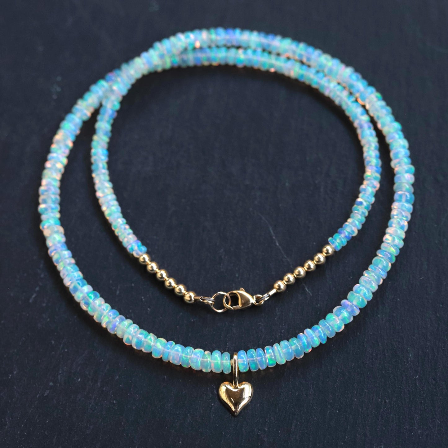 Ethiopian Opal heart necklace with 14K gold chain from Earthly Abundance, showcasing a vibrant, heart-shaped gemstone pendant.