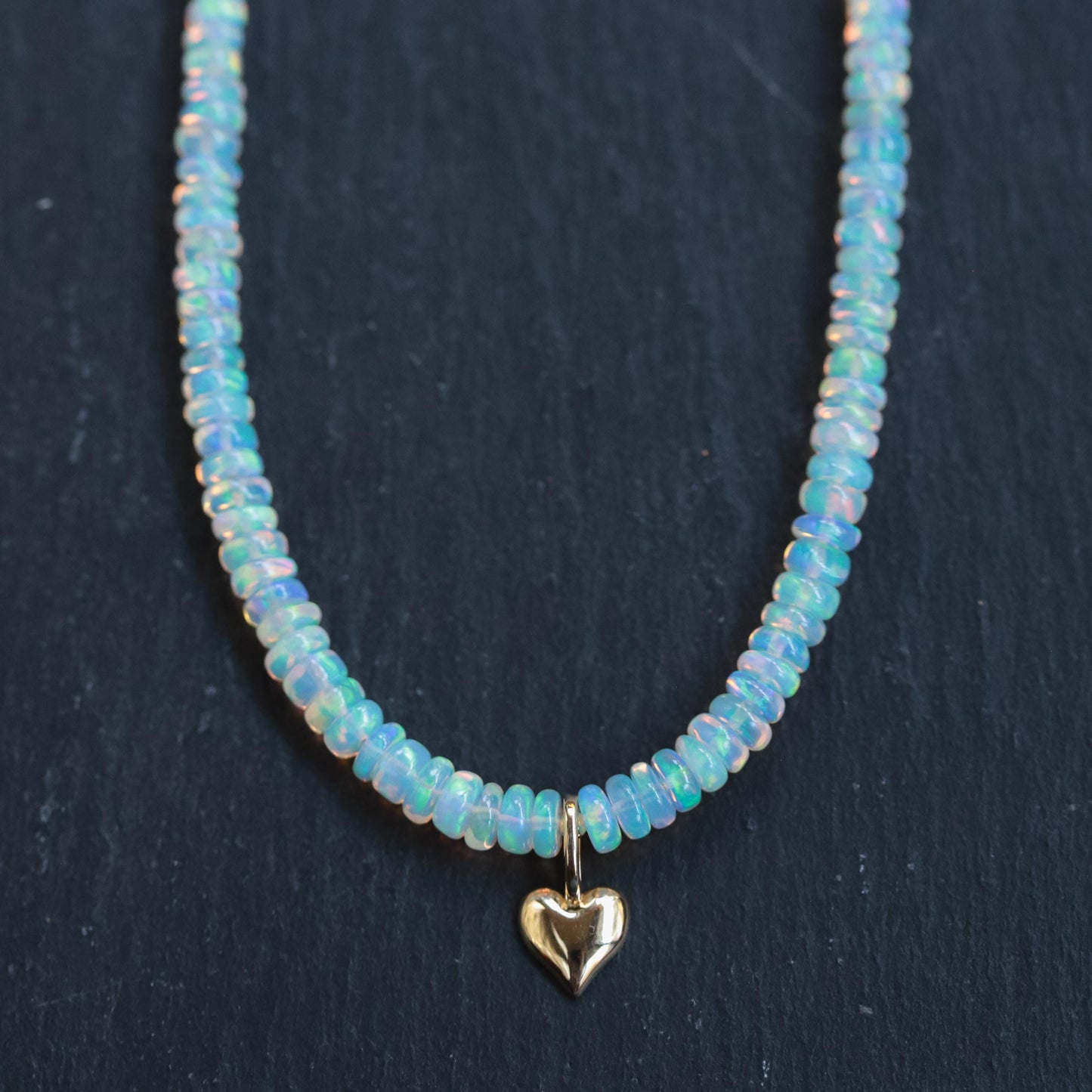 Ethiopian Opal heart necklace in 14K gold from Earthly Abundance, showcasing a sparkling heart-shaped opal pendant.