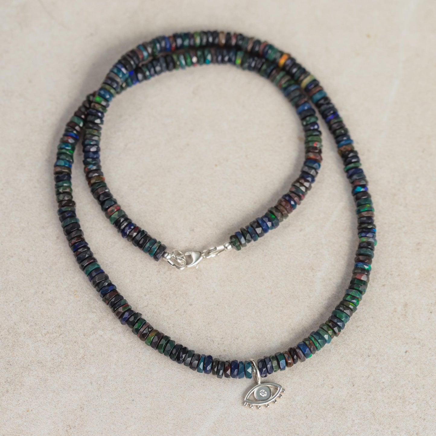 Black Ethiopian Opal diamond evil eye pendant featuring a shimmering gemstone and protective evil eye design.