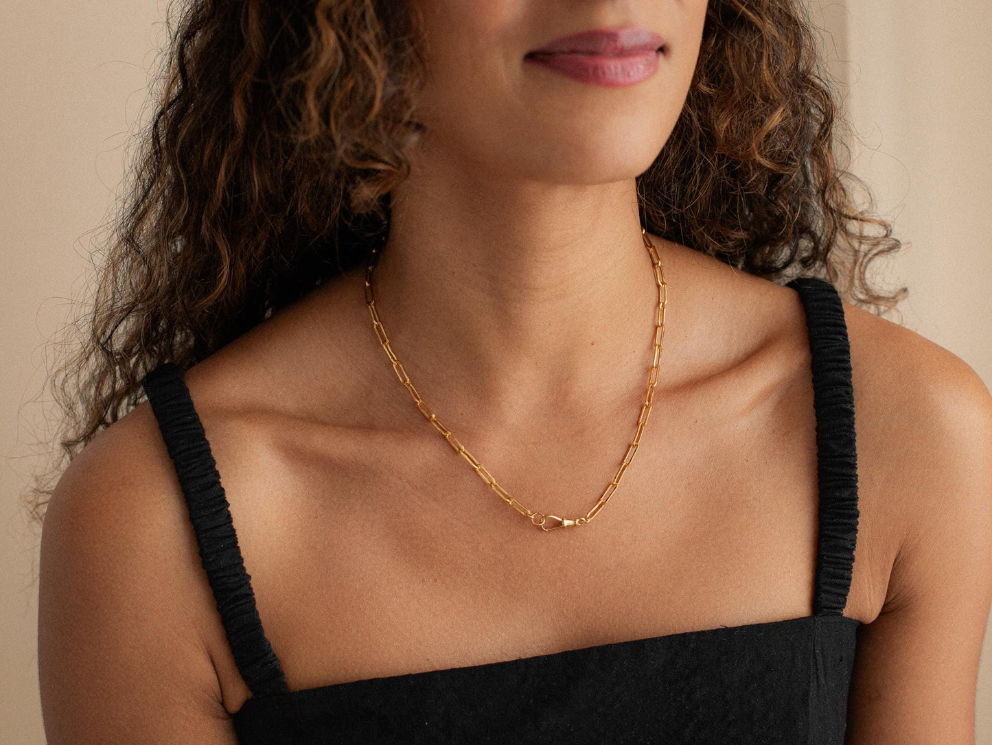 14K gold-filled swivel paperclip chain from Earthly Abundance, featuring shiny interlocking paperclip links on a white background.