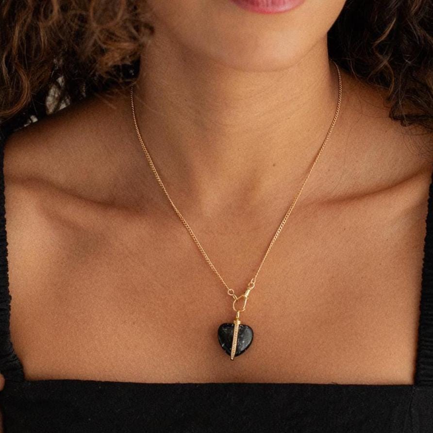 Black Tourmaline heart pendant from Earthly Abundance, showing a polished black gemstone heart with silver chain.