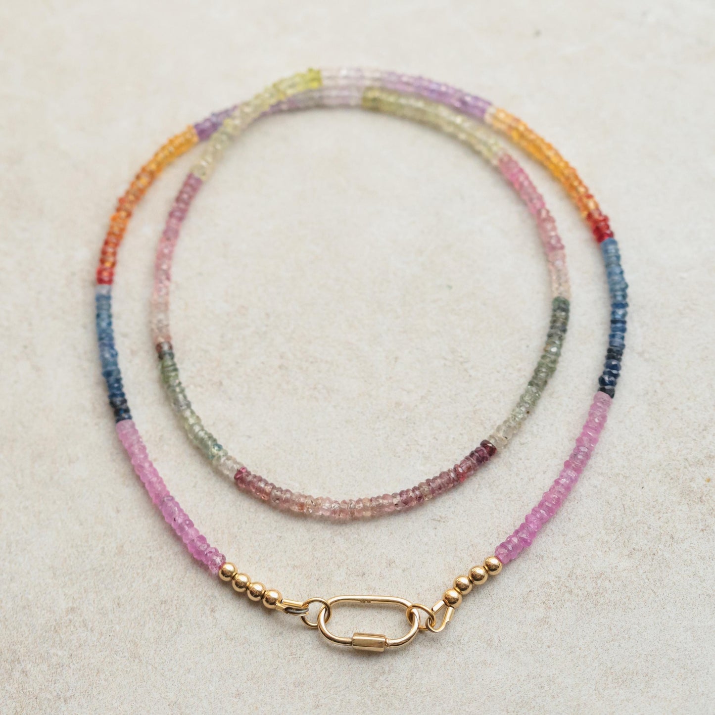 Multi sapphire carabiner necklace by Earthly Abundance featuring vibrant sapphires and a sleek metal chain.