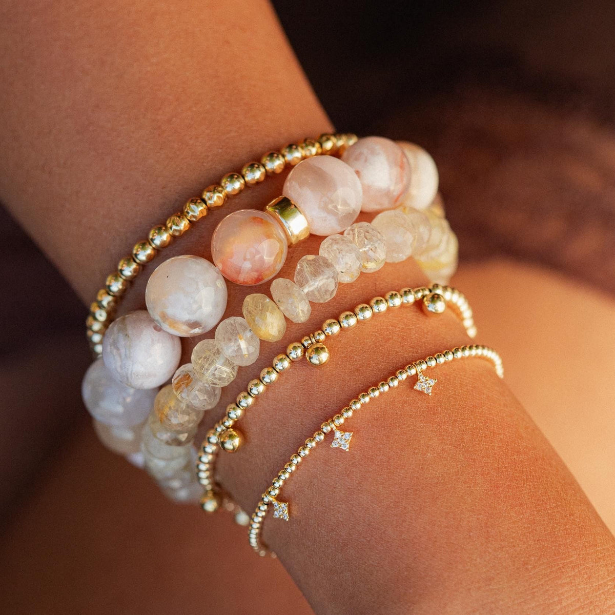 Flower agate bracelet with 14K gold accents from Earthly Abundance, showcasing vibrant flower patterns and polished gemstone beads.