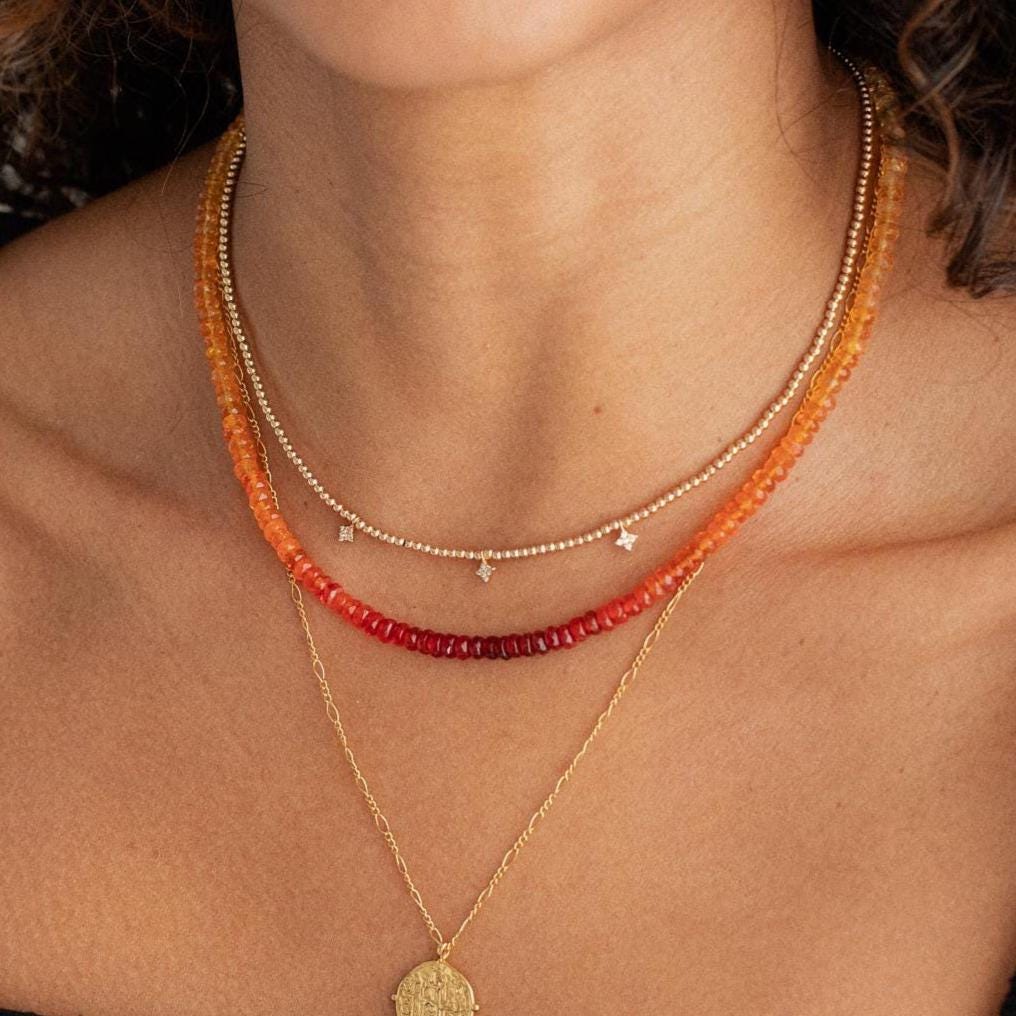 Mexican fire opal necklace with 14K gold setting from Earthly Abundance, featuring vibrant orange-red gemstone on a delicate chain.