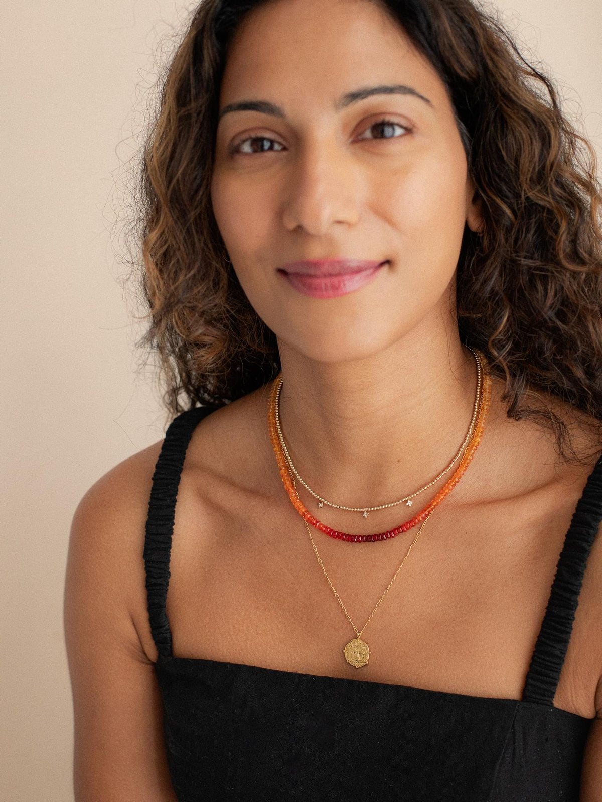 Mexican fire opal necklace with 14K gold setting, featuring vibrant orange-red gemstones on a delicate chain.
