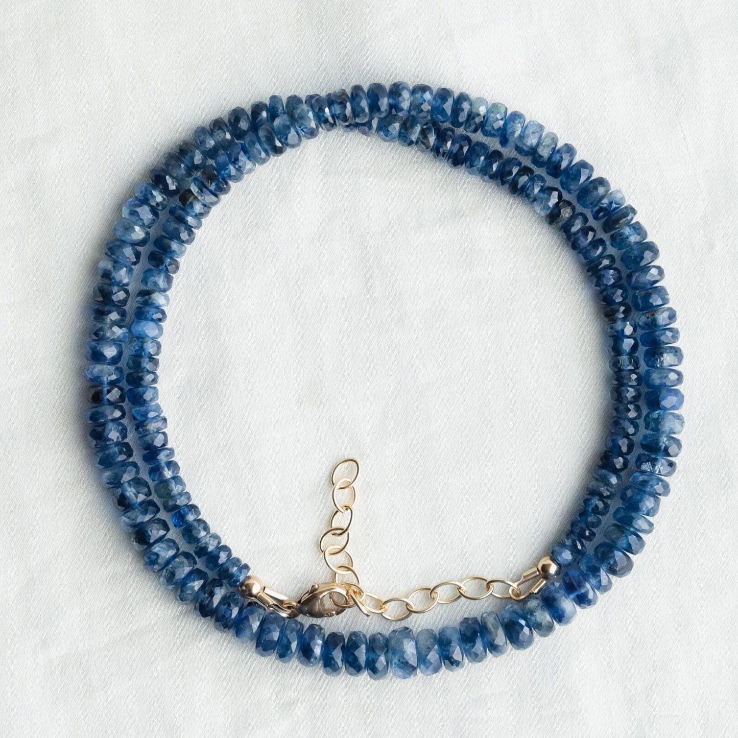 Kyanite gemstone necklace from Earthly Abundance featuring a polished blue crystal pendant on a silver chain.