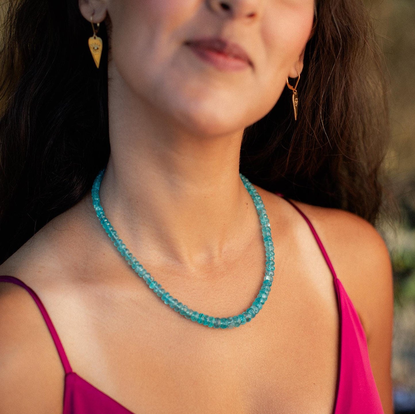 Glowing apatite necklace with vibrant blue-green stones on a delicate silver chain, elegant jewelry by Earthly Abundance.