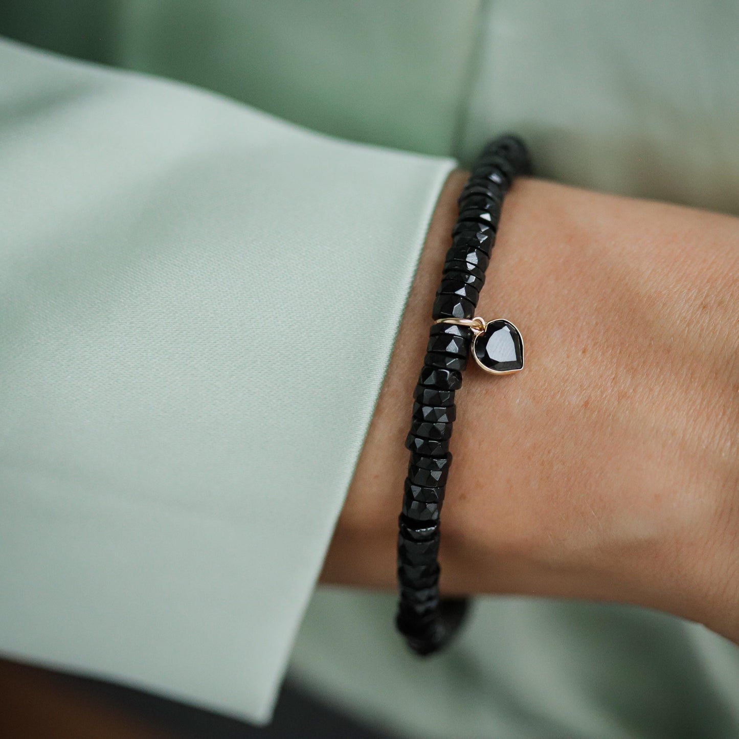 Black spinel heart bracelet in 14K gold, featuring a delicate design and polished finish, by Earthly Abundance.