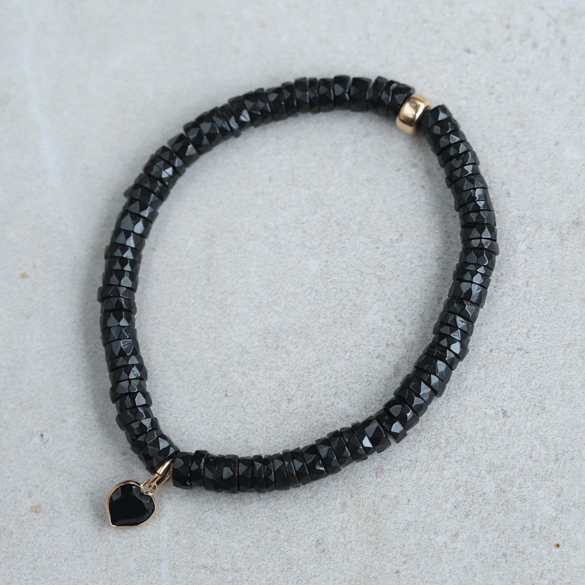 Black spinel heart bracelet with 14K gold accents, showcasing elegant jewelry design by Earthly Abundance.
