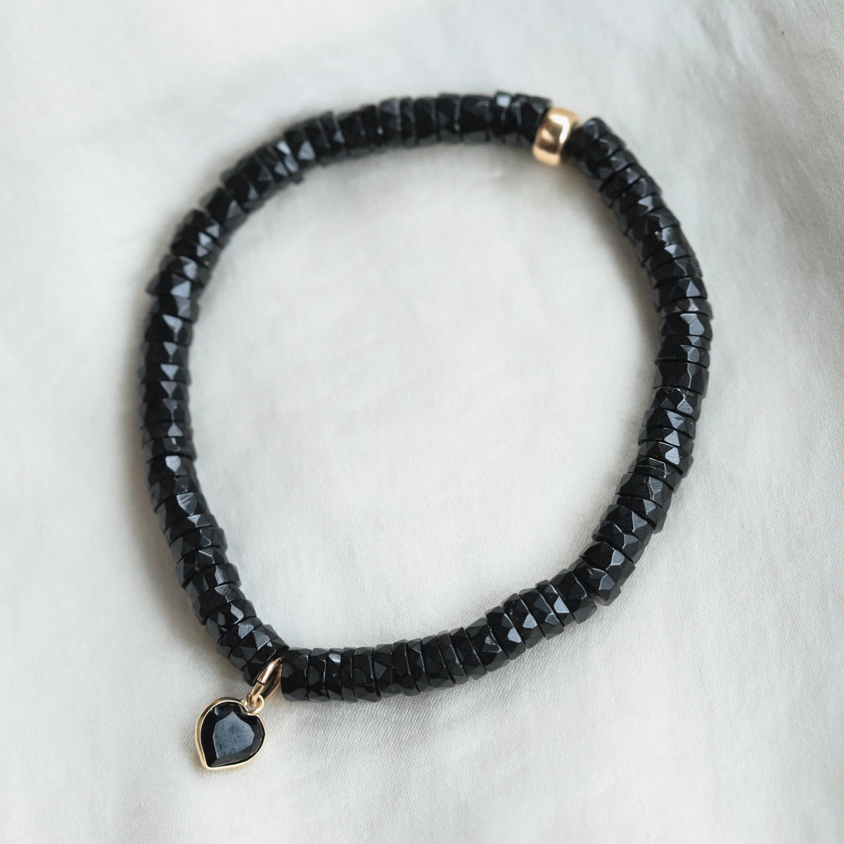 Black spinel heart bracelet with 14K gold accents from Earthly Abundance, featuring a delicate chain and heart-shaped black spinel charms.