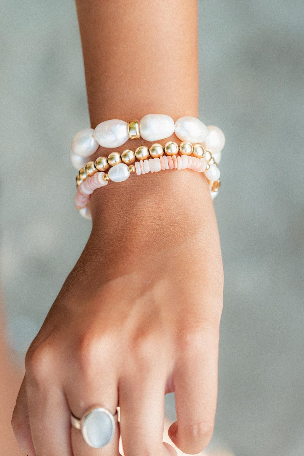 Stacked pearl and gold harmony rings from Earthly Abundance, showcasing elegant jewelry with lustrous pearls and gold accents.