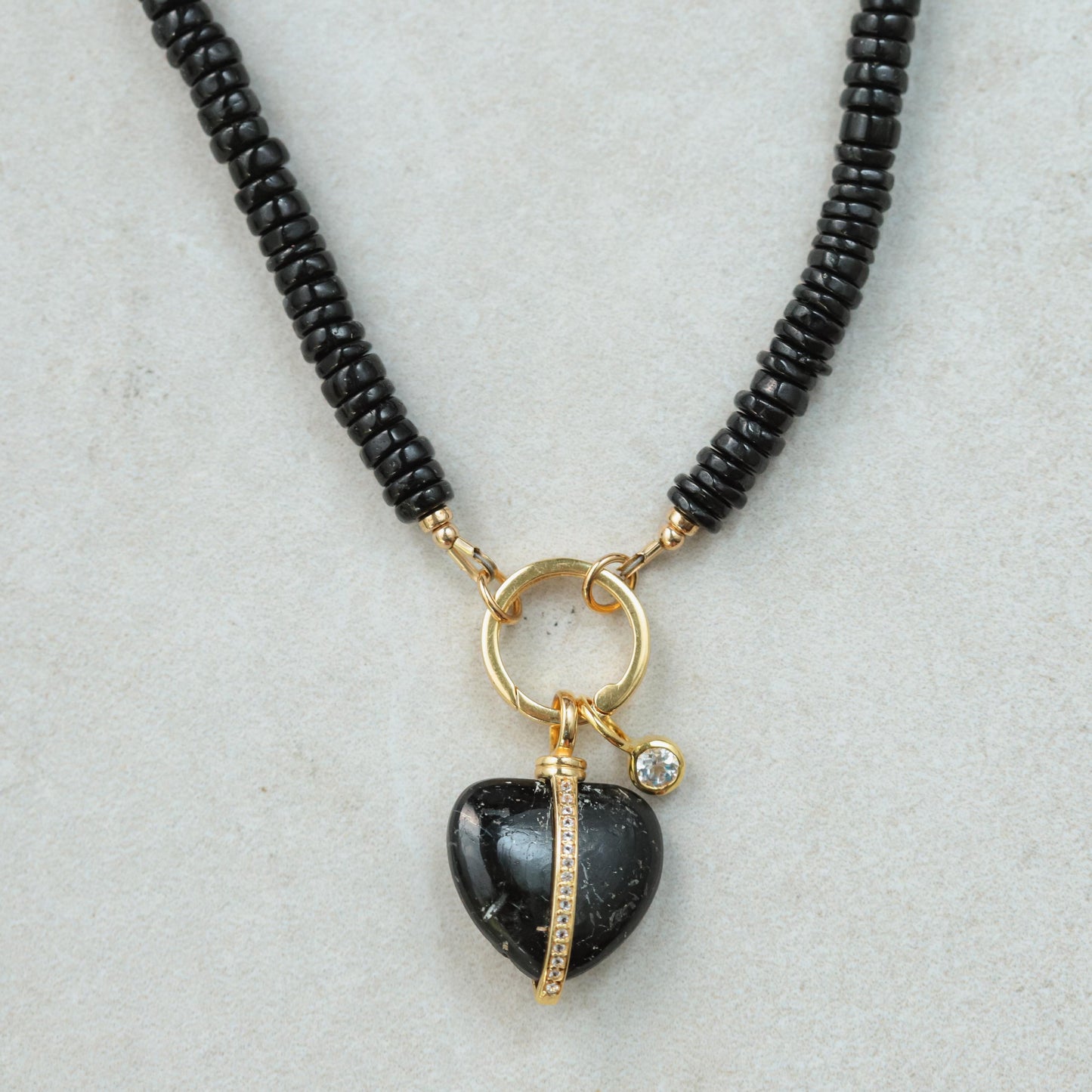 Black spinel and heart-shaped topaz necklace with silver chain from Earthly Abundance, featuring sparkling gemstones.