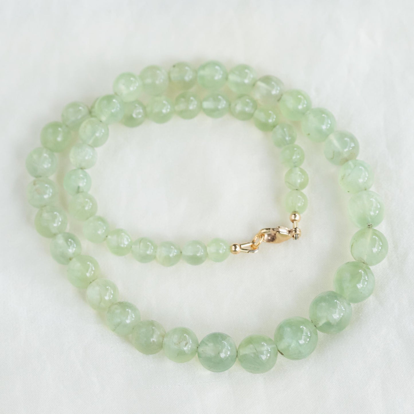 Prehnite glow necklace featuring a polished green prehnite pendant on a delicate chain, designed by Earthly Abundance.