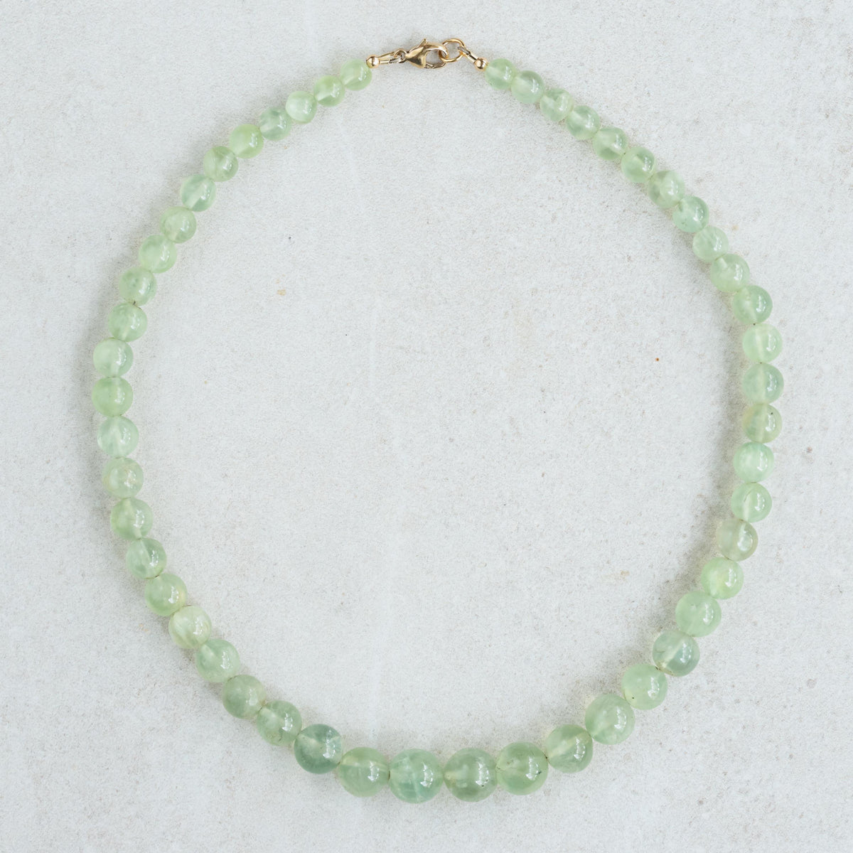 Prehnite glow necklace by Earthly Abundance featuring a smooth green gemstone pendant on a silver chain.