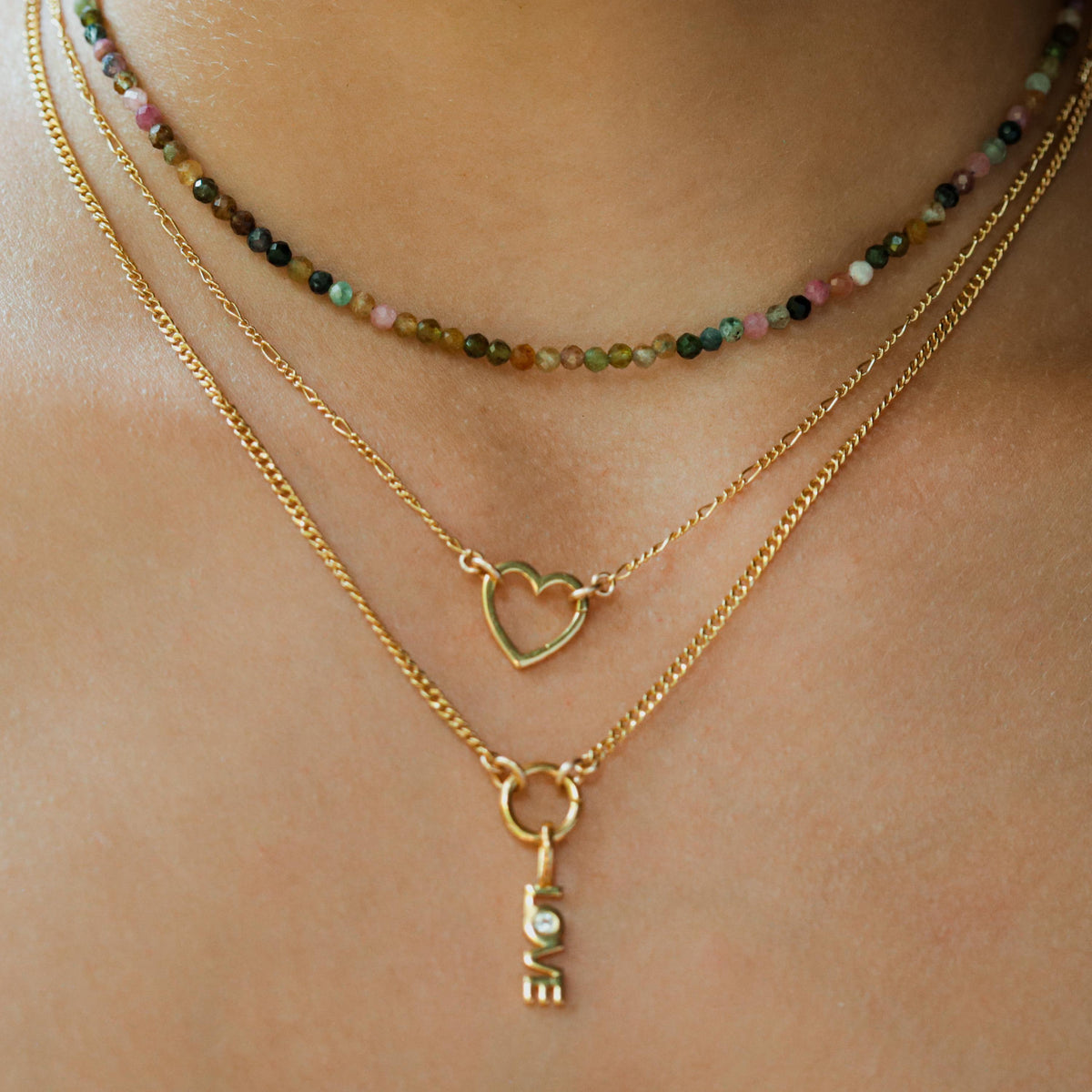 14k gold filled Figaro chain necklace by Earthly Abundance, showcasing a sleek, layered chain design on a neutral background.