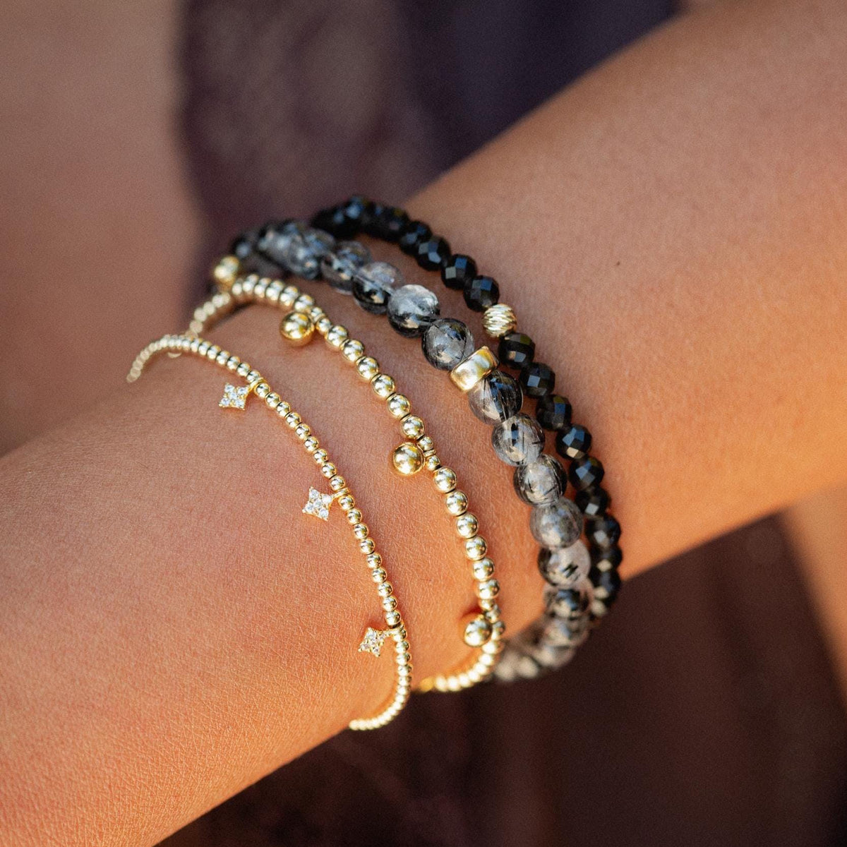 Obsidian Snake Bracelet in 14K gold featuring a detailed snake design, crafted by Earthly Abundance.