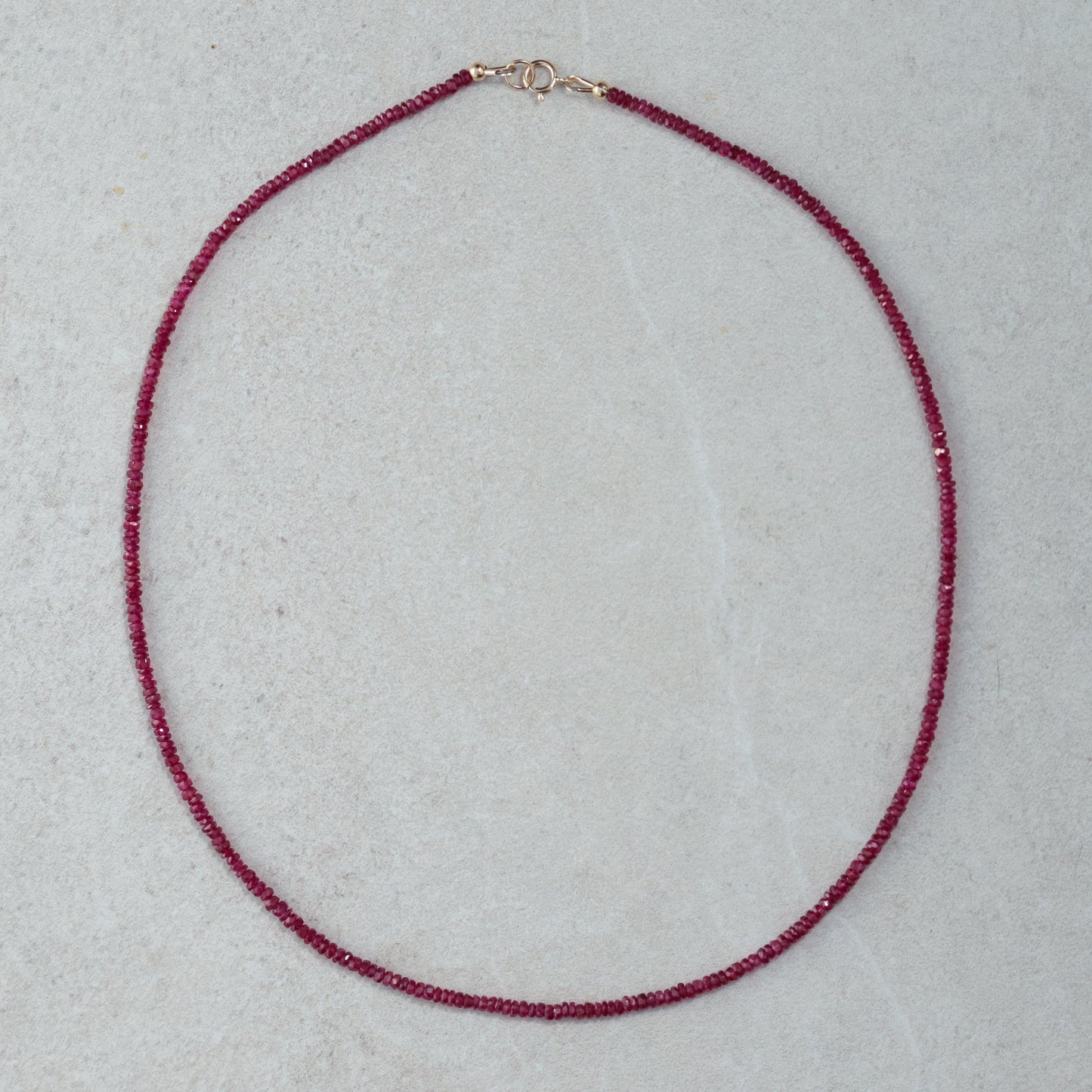 Carmine Longido Ruby Necklace by Earthly Abundance featuring deep red rubies on a delicate gold chain.
