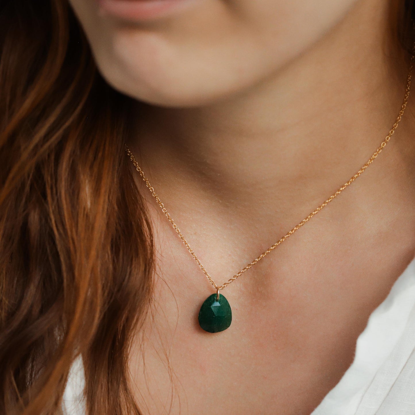 Green aventurine pendant in 14K gold setting, featuring a polished, oval-shaped gemstone on a delicate chain.