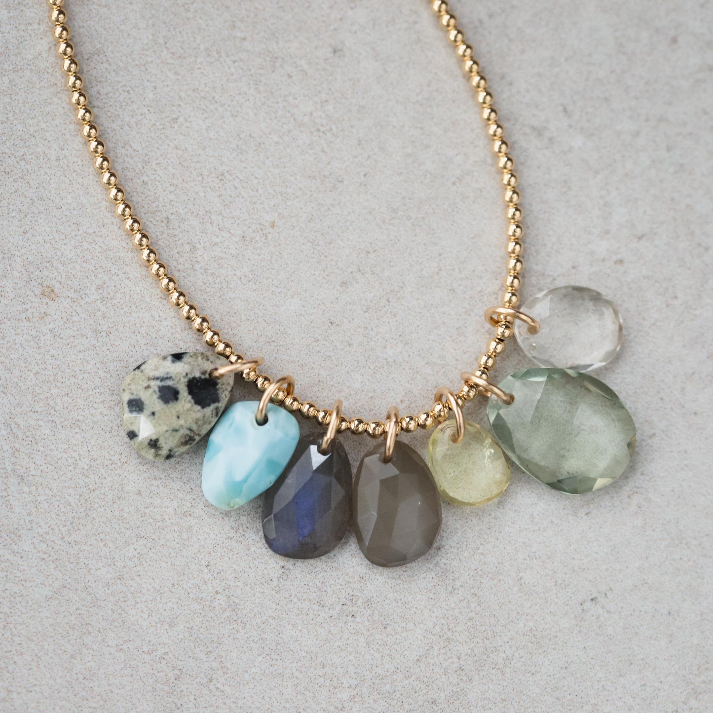 Green aventurine pendant in 14K gold setting, showcasing a polished, vibrant green gemstone with a delicate gold bail.