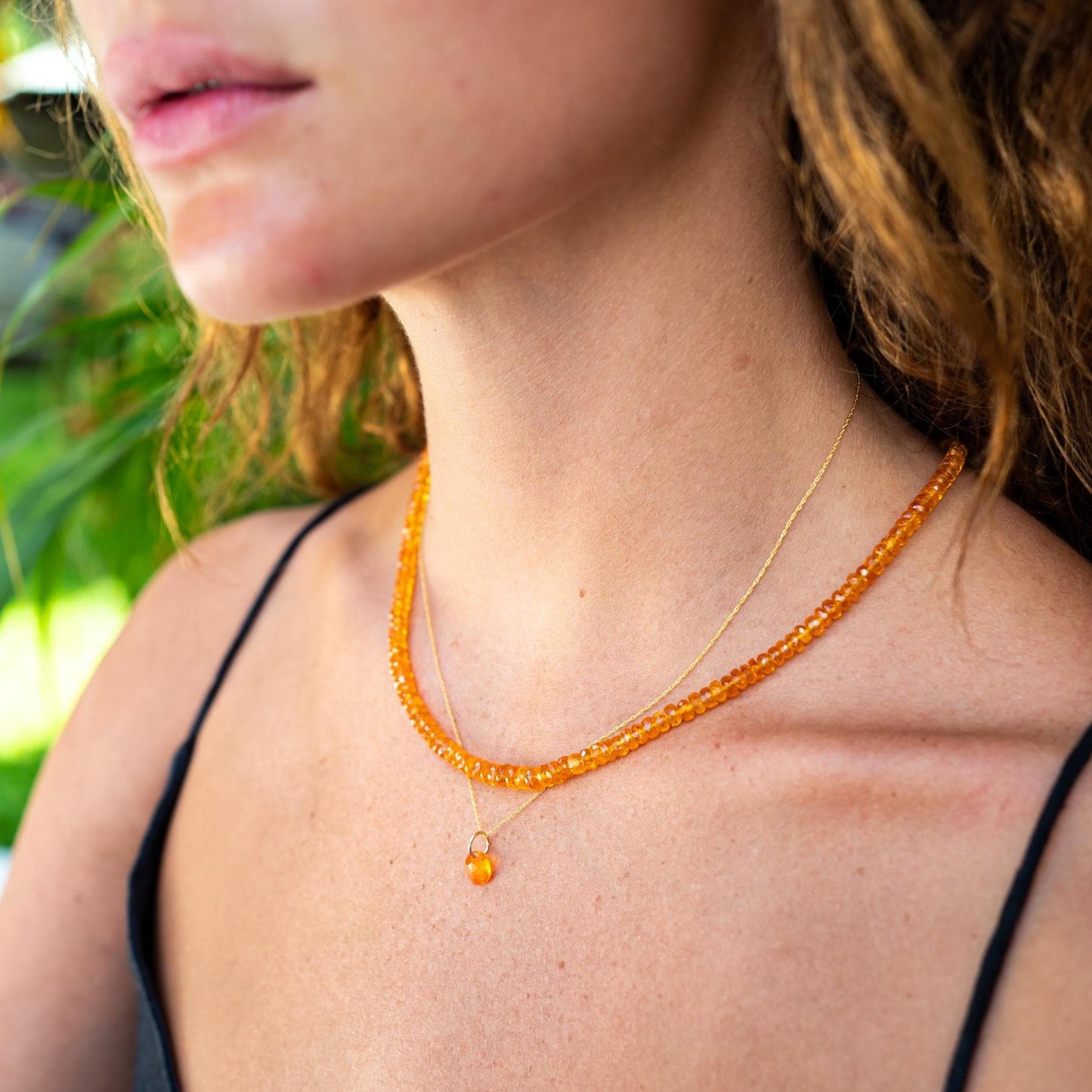 Spessartite garnet necklace with 14K gold chain, featuring vibrant orange-red gemstones, elegant jewelry piece.