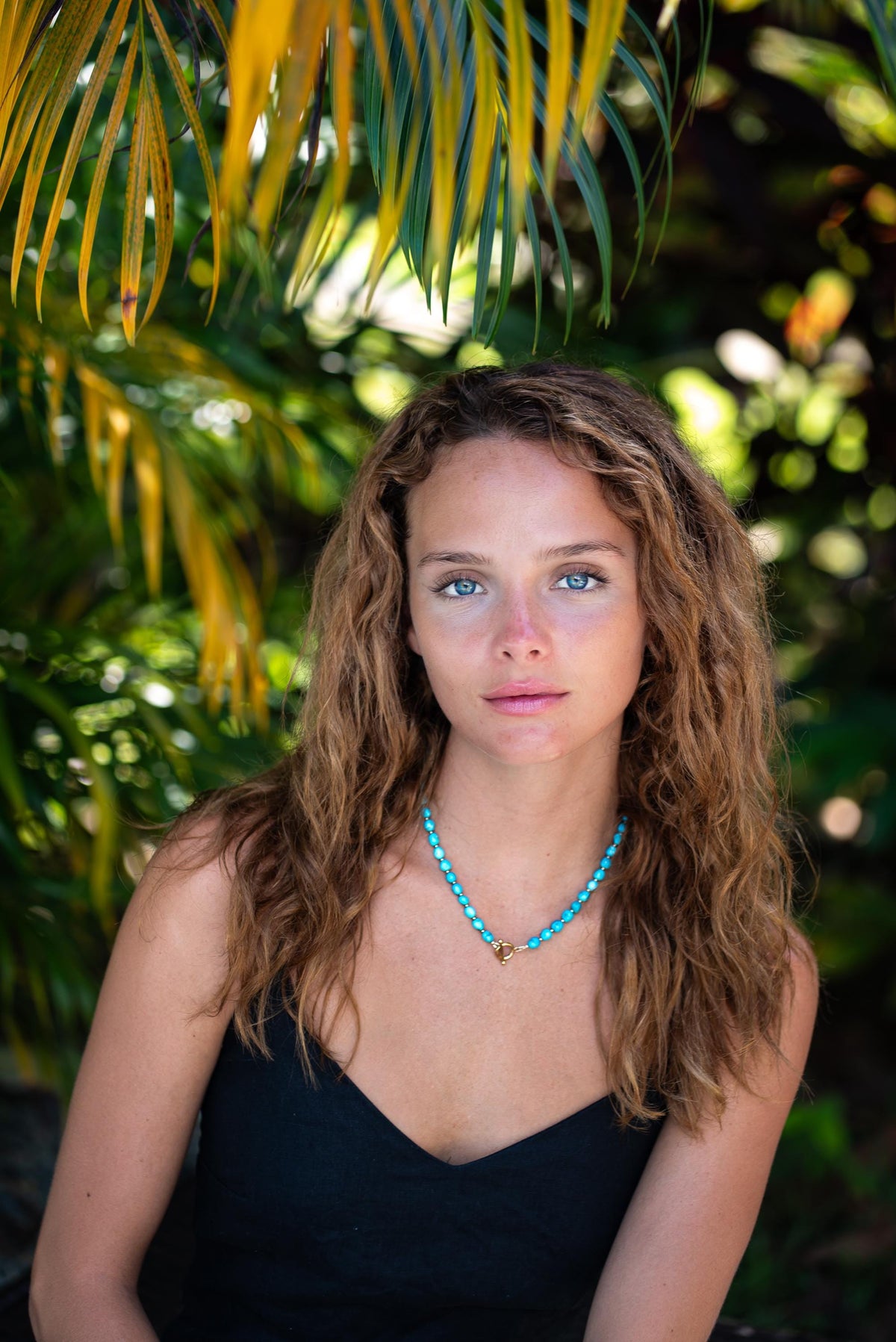 Earthly Abundance Sleeping Beauty toggle necklace featuring a vibrant, faceted gemstone pendant on a silver chain.