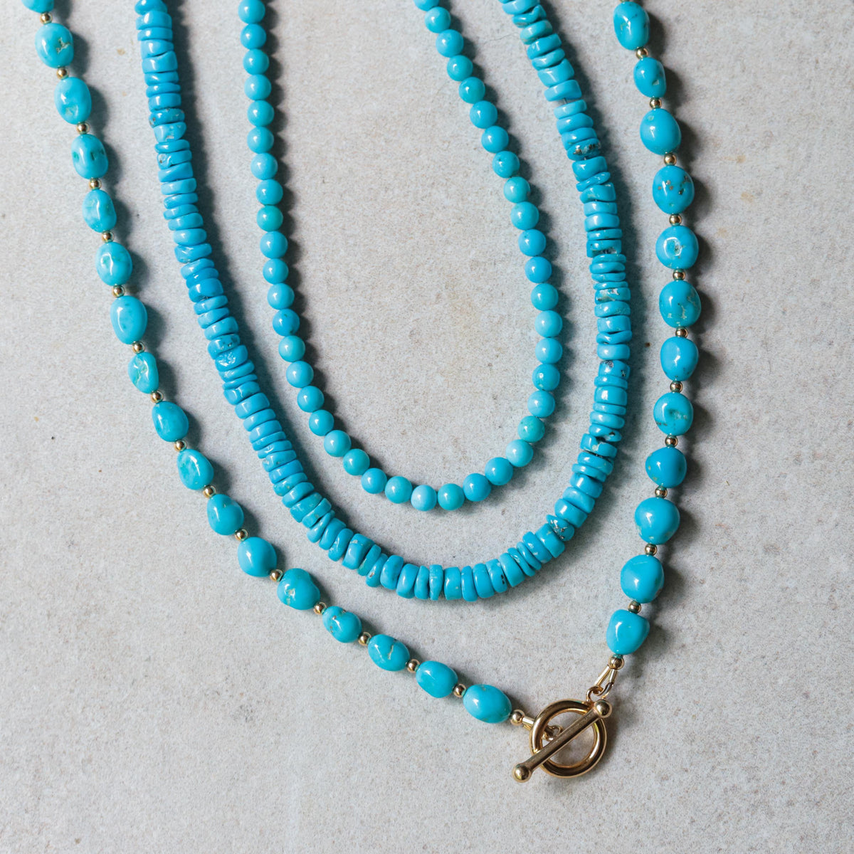 Sleeping Beauty toggle necklace by Earthly Abundance featuring a vibrant turquoise pendant on a silver chain.
