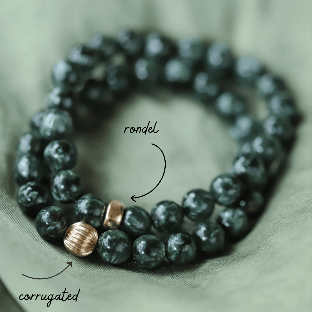 Eight-millimeter Seraphinite gemstone beads from Earthly Abundance Jewelry, displayed in a bundle of 36.