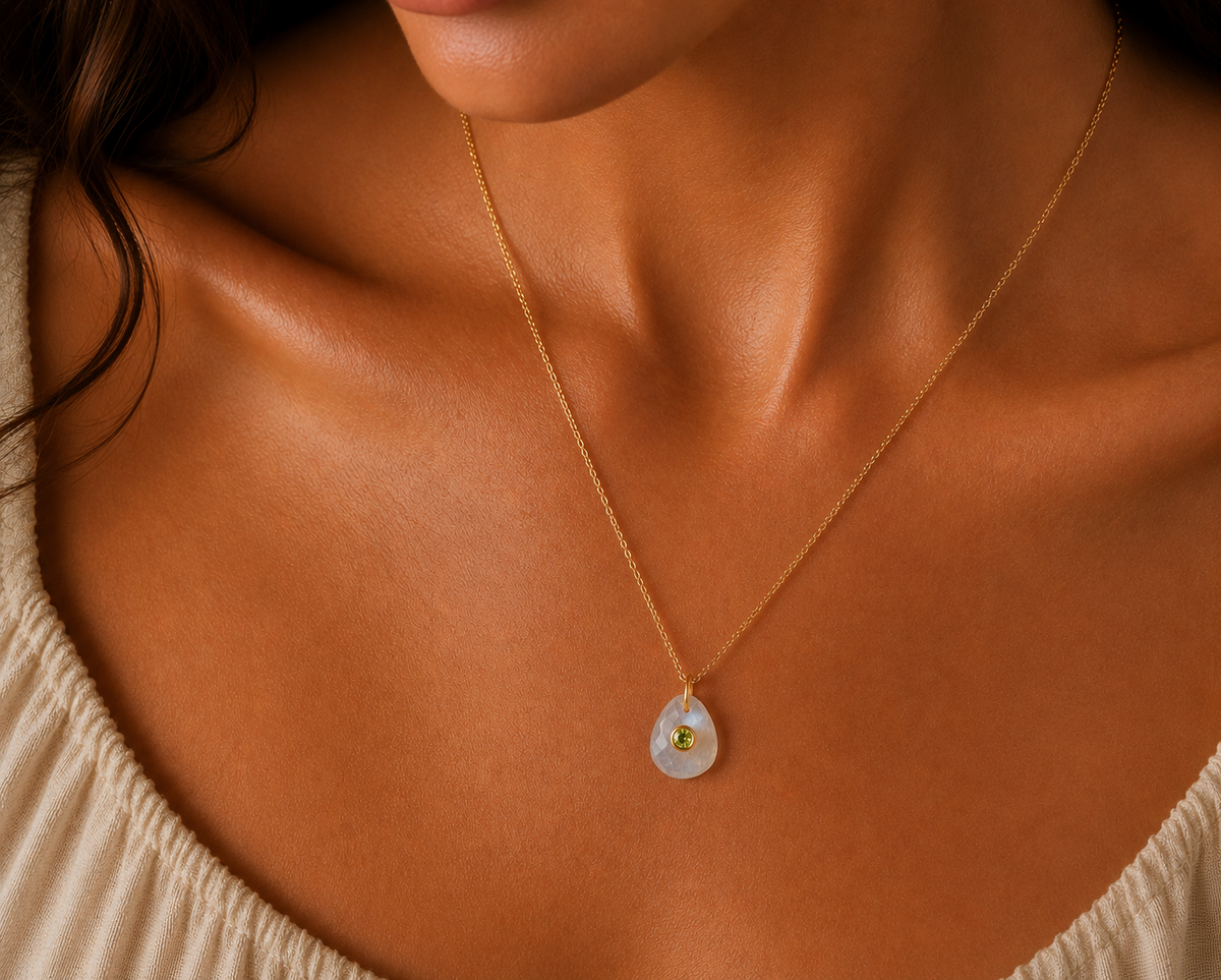 Moonflower pendant featuring moonstone and peridot gemstones, handcrafted by Earthly Abundance, displayed against a neutral background.