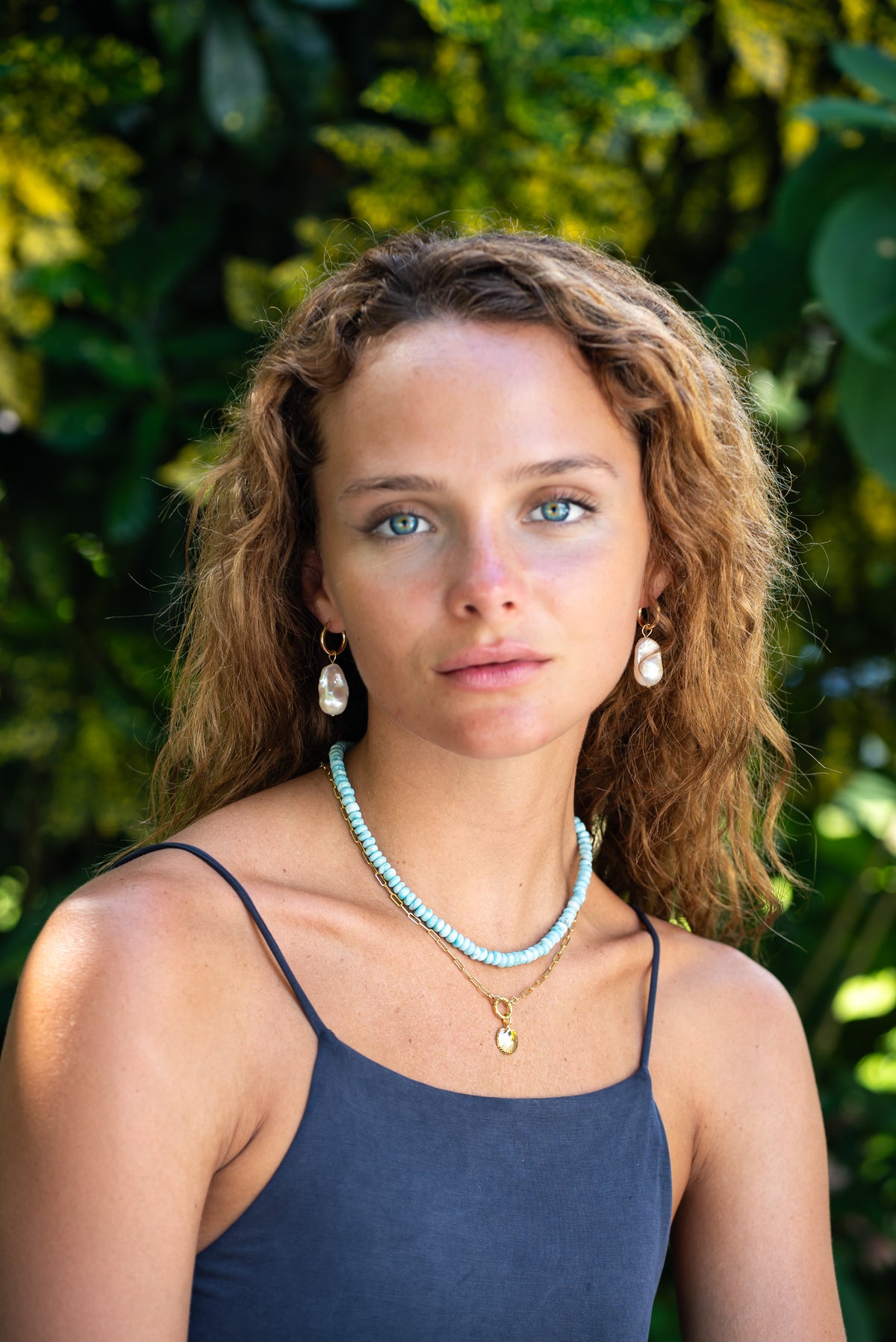 Sea shell carabiner layering jewelry set with natural earth tones, featuring shell charms and metal accents, styled for layered look.