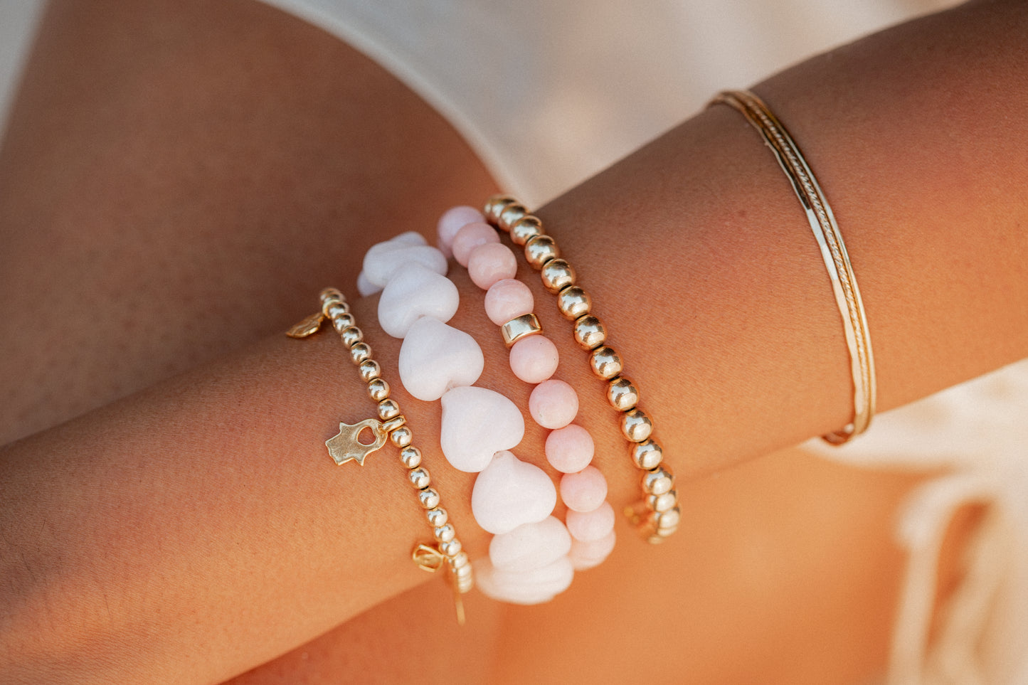 Pink mango calcite heart-shaped bracelet by Earthly Abundance Jewelry, featuring polished pink gemstone beads and a heart charm.