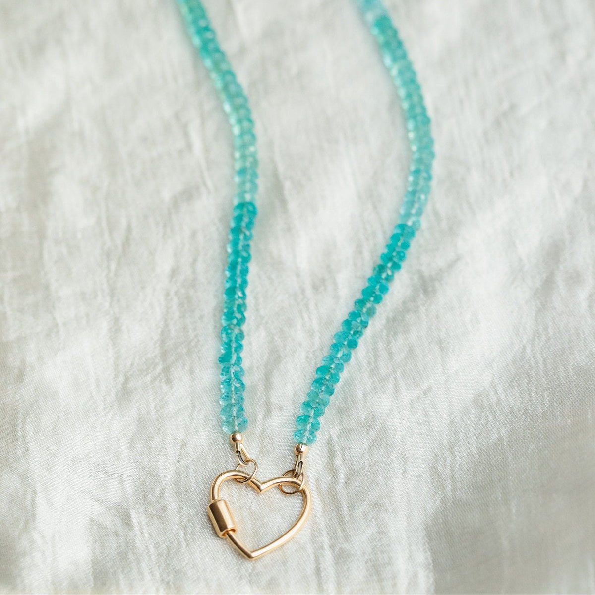 Aapatite heart carabiner necklace with a silver chain, featuring a polished blue-green apatite heart pendant from Earthly Abundance Jewelry.