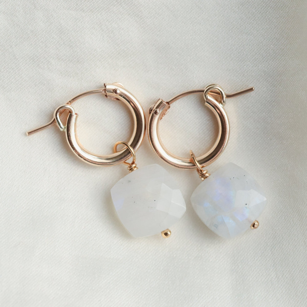 Rainbow moonstone hoop earrings by Earthly Abundance featuring polished hoops with iridescent moonstone stones.