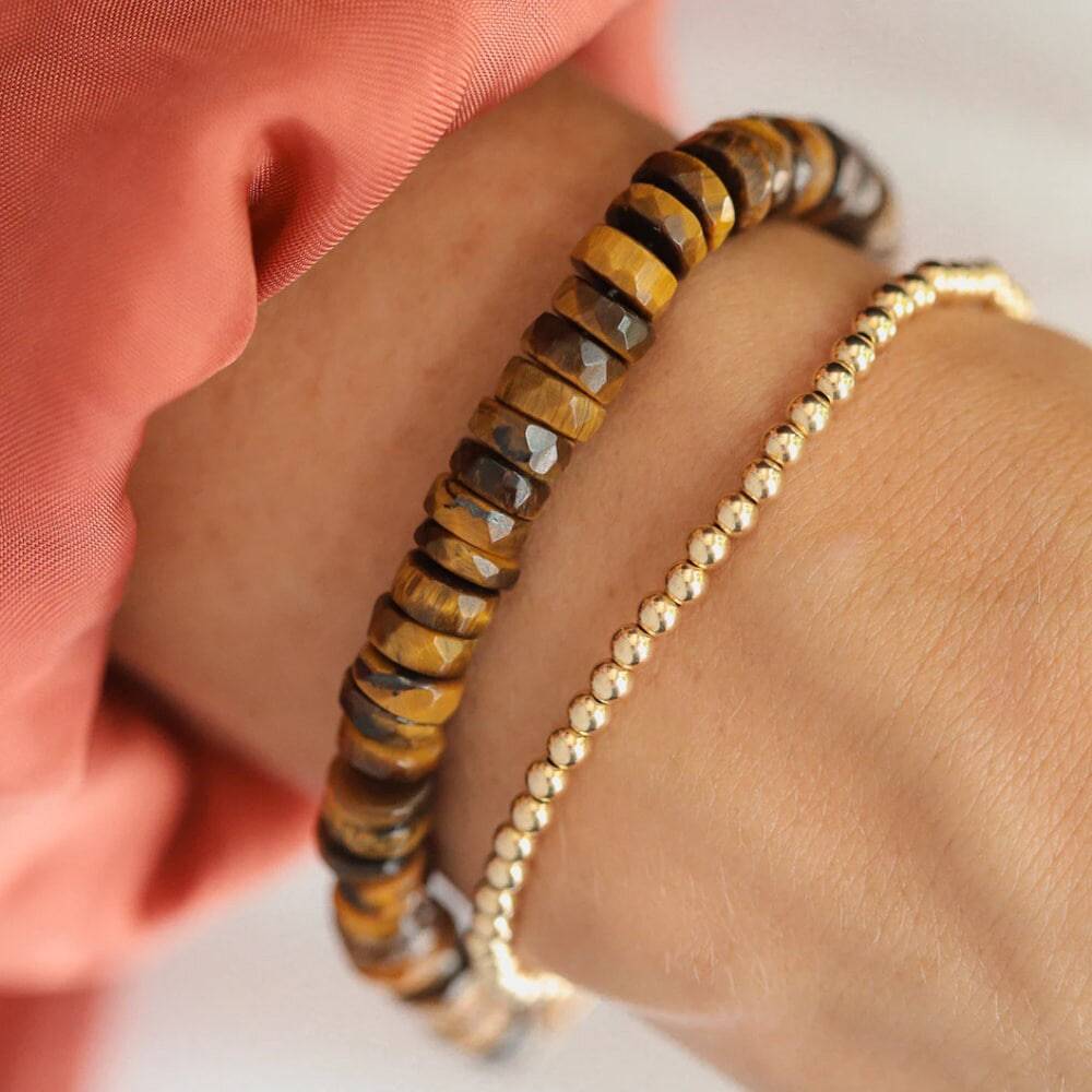 Earthly Abundance Tiger's Eye Heishi bracelet featuring smooth, round tiger's eye beads on an elastic cord.