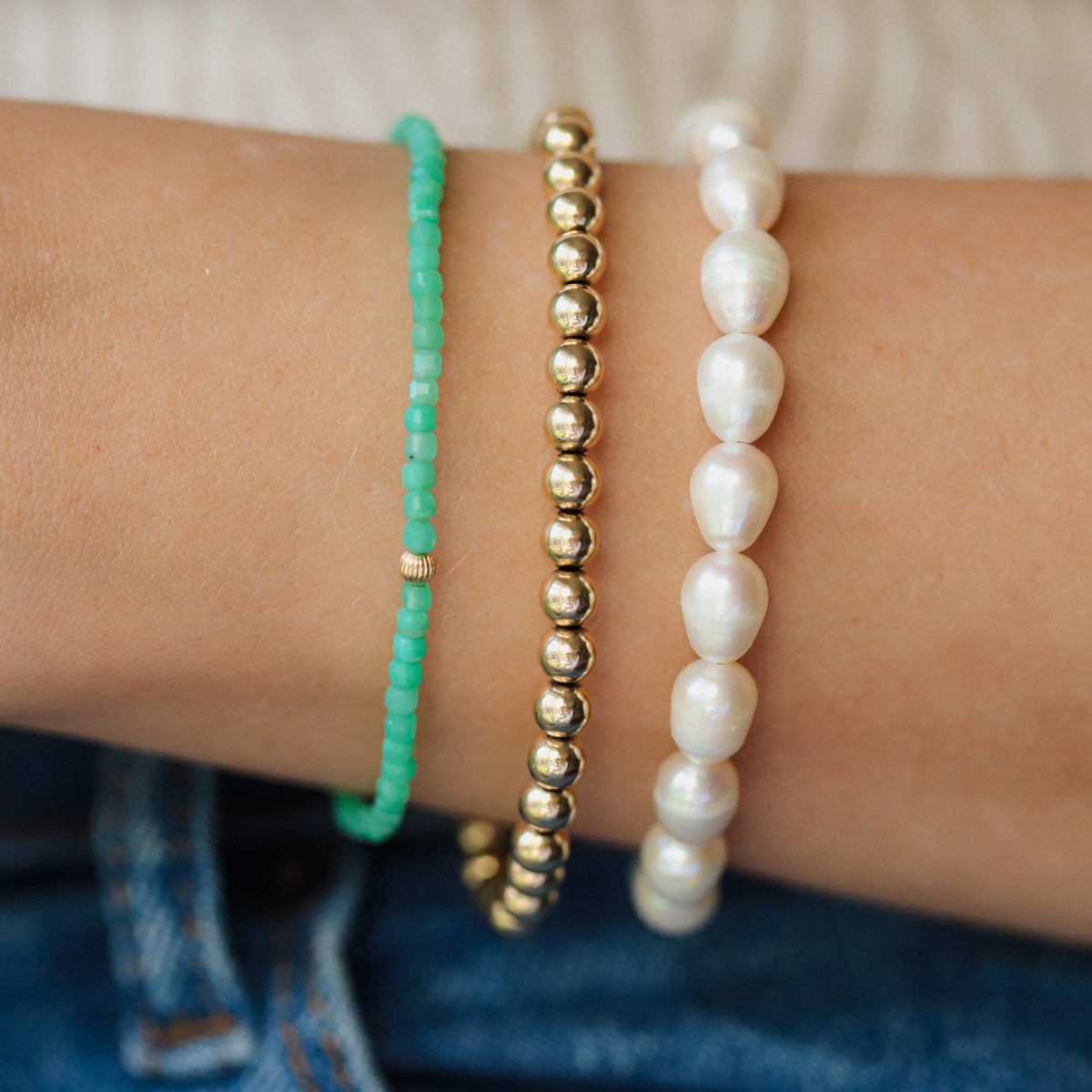 Freshwater pearl bracelet with 14K gold-filled clasp, featuring lustrous white pearls and elegant gold accents.