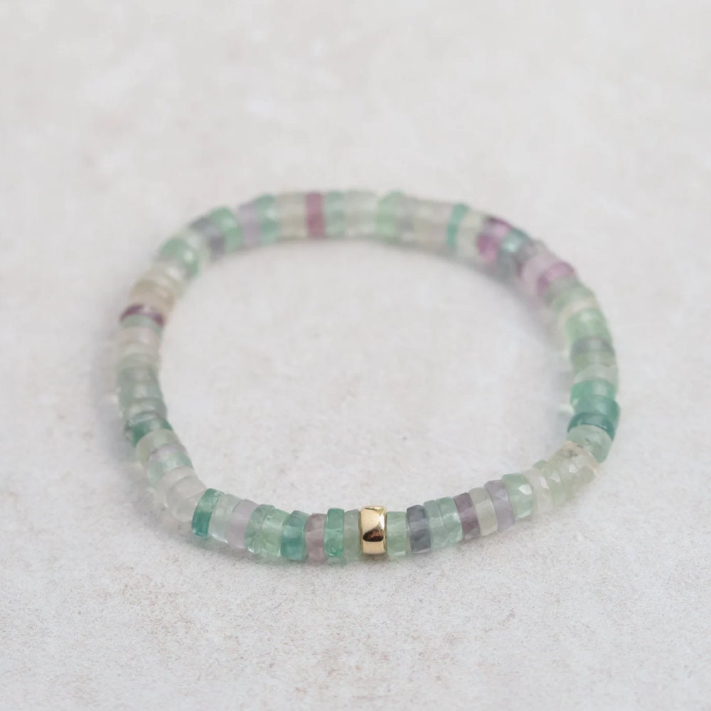 Fluorite heishi bracelet from Earthly Abundance featuring smooth, colorful fluorite beads strung together on elastic cord.