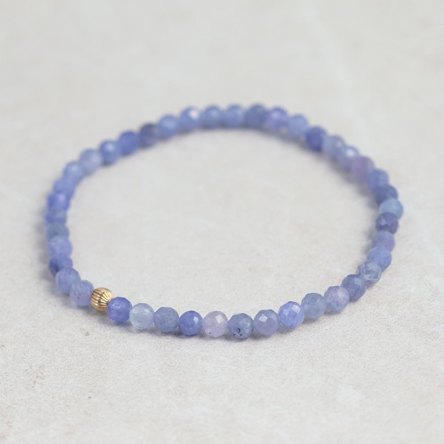 Earthly Abundance Higher Insight Tanzanite bracelet featuring vibrant blue and purple tanzanite gemstones on a delicate silver chain.